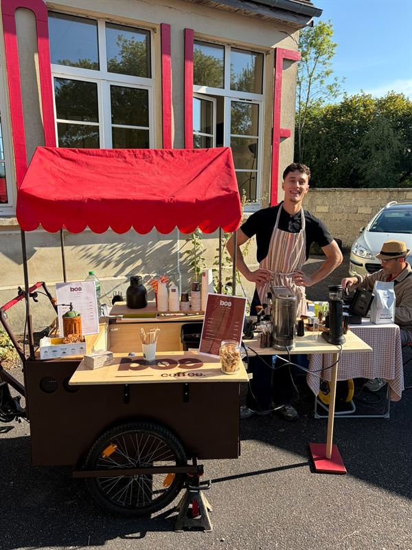 Lucien, barista de Boé Coffee, devant son triporteur aménagé en bar à café